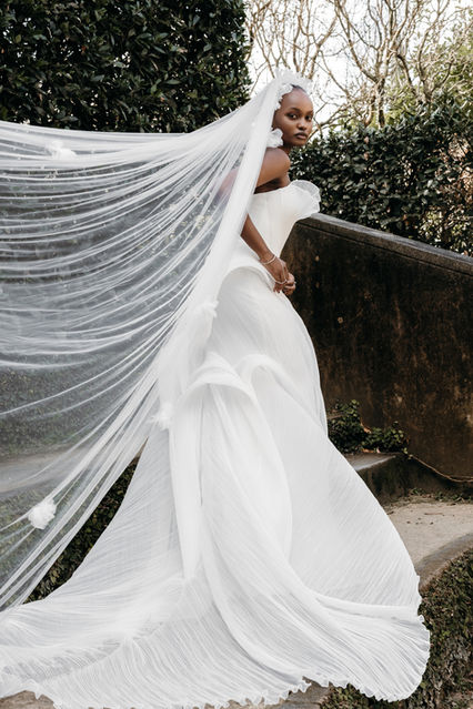 Ready to marry your Romeo ? The Juliette gown showcases intricate artistry of fine pleated organza, sculpting the body with graceful precision. A beautiful framework of texture is created, underneath which sits a fully boned inner corset for a secure and flattering fit, ensuring both comfort and confidence. Elegant twists and turns of pleated texture cascade into a magnificent full train, captivating with its timeless beauty and grandeur.