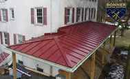 Striking red standing seam metal roof installed by Bonner Master Roofing 