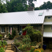 Home with a standing seam metal roof, showcasing clean lines, durability, and modern architectural style.