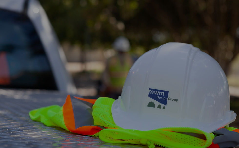 White hard hat and safety vest on truck, MWM DesignGroup logo