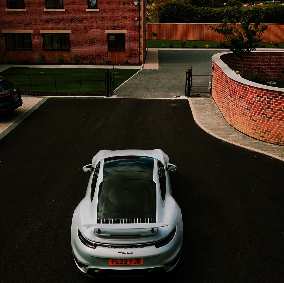 porsche car in driveway with house in background