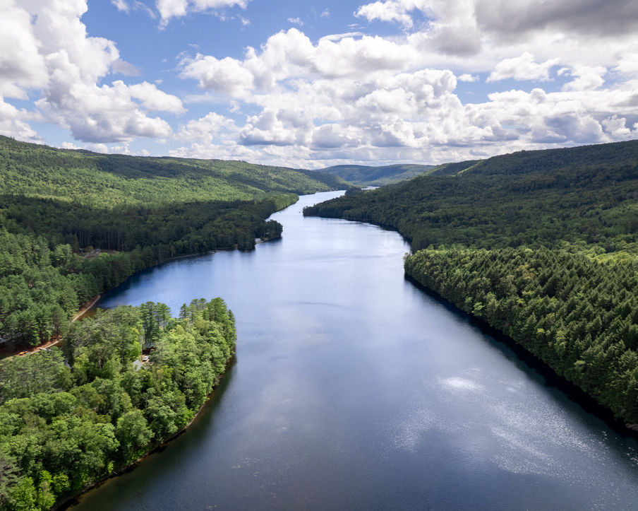 Aerial view of a river running between trees as far as the eye can see. Maine wedding, Maine river.