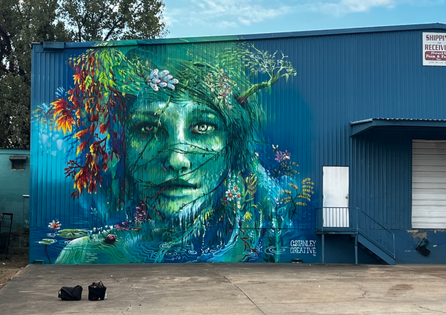 The Green Lady mural is in Memphis, TN. It features a woman made out of and covered in local flora and fauna. This mural was a part of the Paint Memphis Festival.