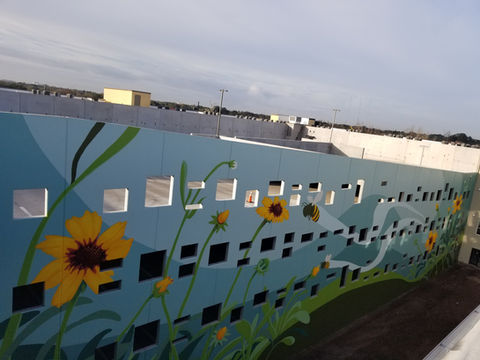 This massive mural depicts a peaceful scene of native wildflowers and bees. It was painted by muralist Christian Stanley in 2021. 