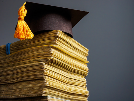 A stack of money with a college graduation cap on top