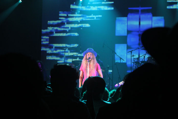 Erykah Badu in concert with Blue light; photo is a shot from the crowd
