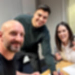 Paul Jarrett, Marcus Quevedo, and Stephanie Jarrett pose for a photo while signing for Victor Leigh LLC