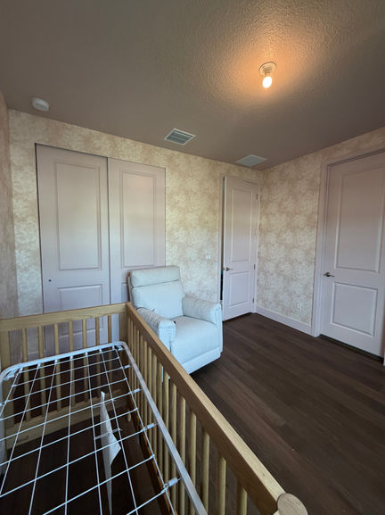 Atmospheric wallpaper nursery doorway and painted trim in Lantana FL