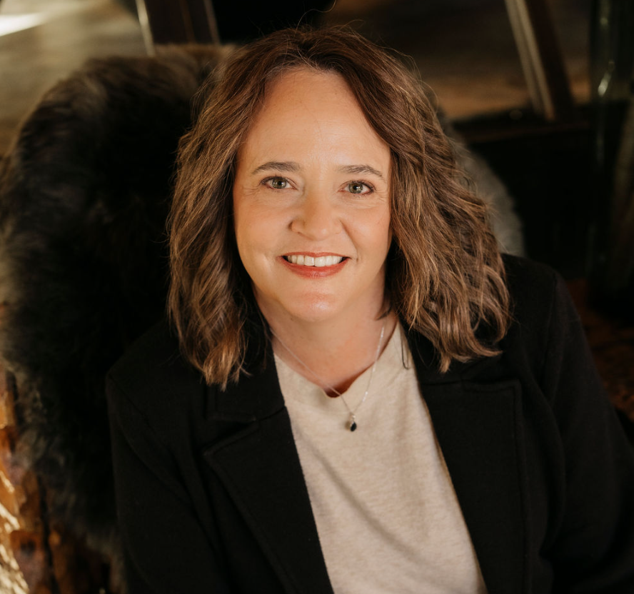 Portrait of, Becky Johnston, a smiling therapist in a warm indoor setting