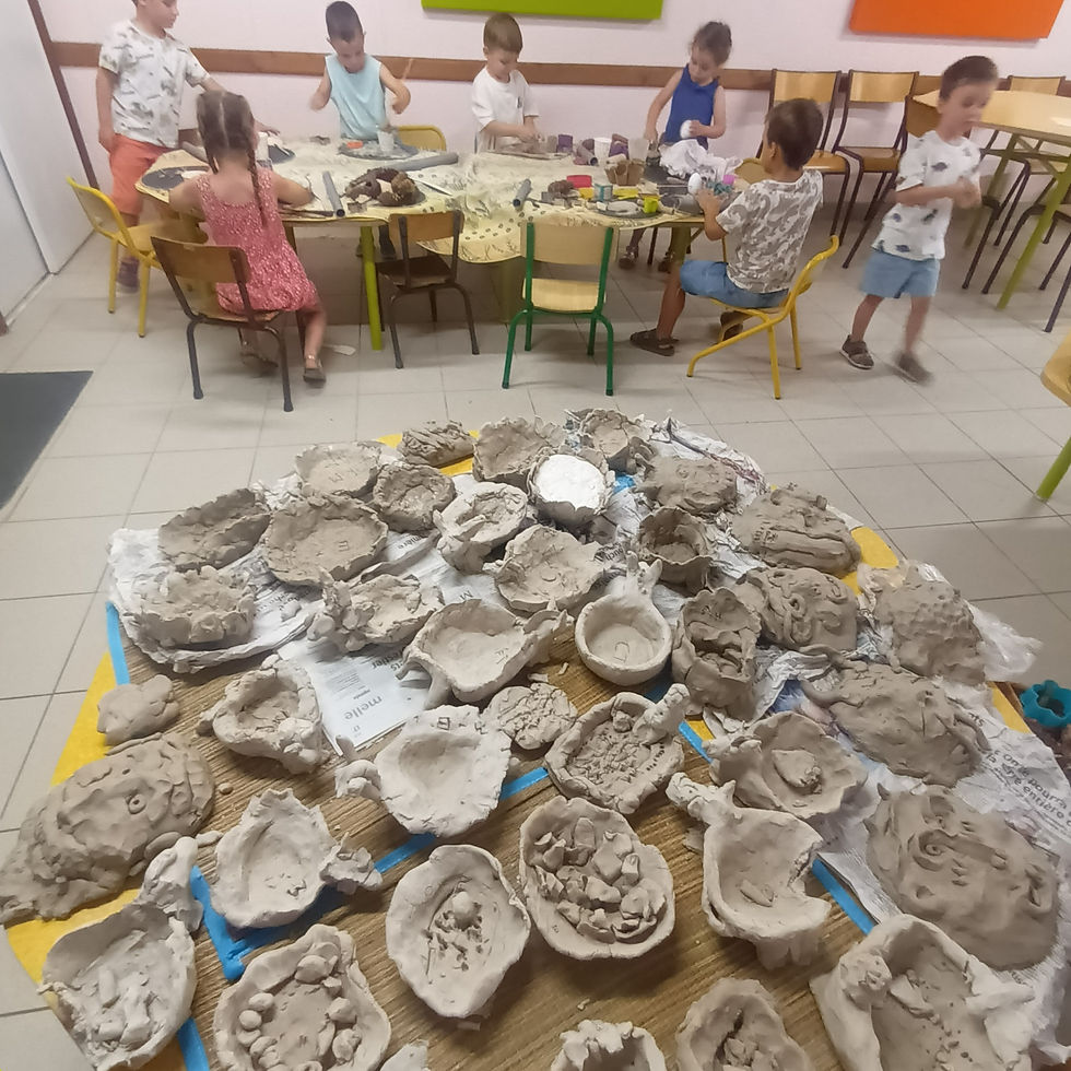 Vue latérale d’un enfant tenant une pièce d’argile façonnée, atelier poterie Saint Rémy