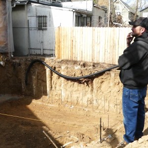 Owner of Gold's Concrete assesses preparation for new foundation.