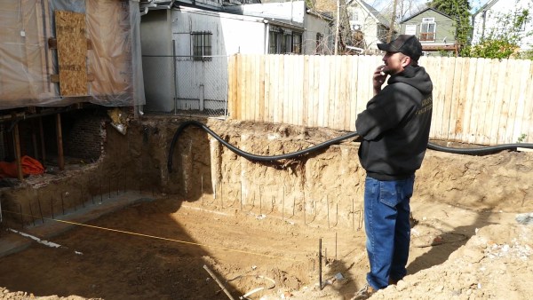 Owner of Gold's Concrete assesses preparation for new foundation.