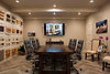 Conference room with large wooden table, modern chairs, wall-mounted screen, and design material samples – Buchanan Commercial Construction, Asheville