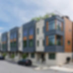 Modern upscale townhomes with multiple stories and large windows on bright day.