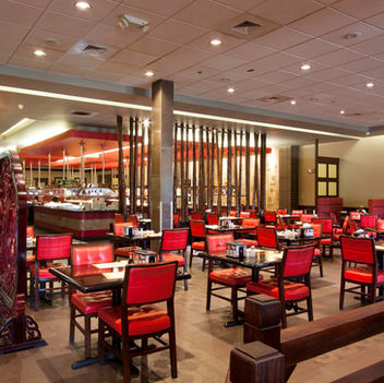 Dining room at YAO Restaurant in Asheville featuring red seating, dark wood furniture, bamboo accents, and warm ambient lighting – Buchanan Commercial Construction, Asheville.