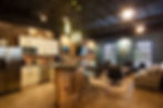 Modern office lounge with exposed ceiling, brick accent walls, kitchenette, and contemporary seating area – Buchanan Commercial Construction, Asheville