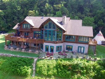 Mountain lodge with wood and stone design, large windows, and scenic forest views — Asheville Bed and Breakfast Association, Asheville, NC.