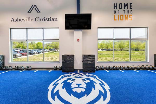 Blue training turf with lion logo inside Asheville Christian Academy’s Strength and Conditioning Center – Buchanan Commercial Construction, Asheville.