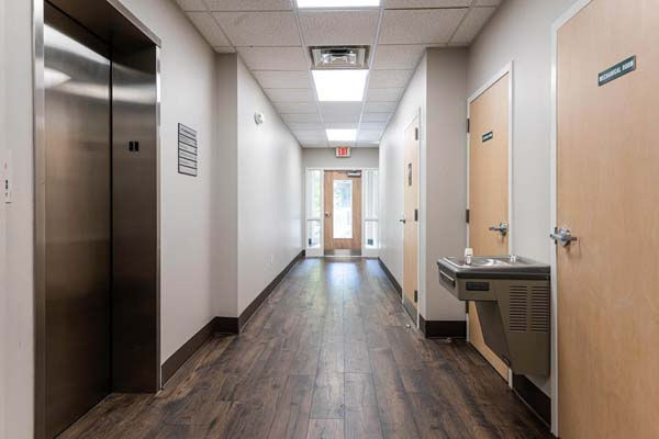 Interior hallway with elevator, water fountain, and office doors at 141 Ashland Avenue – Buchanan Commercial Construction, Asheville.