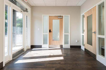 Lobby entrance with glass doors and wood flooring at 141 Ashland Avenue – Buchanan Commercial Construction, Asheville.