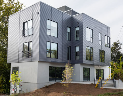 Modern three-story mixed-use building with gray metal siding and large windows, Asheville – Buchanan Construction, Asheville