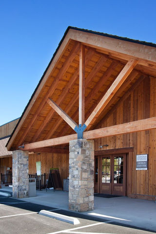 Timber-framed entry with stone columns and exposed beams at Jennings Builder Supply – Buchanan Commercial Construction, Asheville.