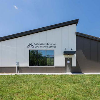 Exterior view of Asheville Christian Academy Golf Training Center with modern steel design and large front window – Buchanan Commercial Construction, Asheville.