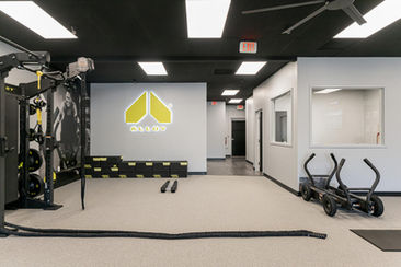 Workout area featuring Alloy logo wall, training ropes, and fitness equipment – Buchanan Commercial Construction, Asheville.