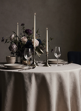 una_pequea_mesa_redonda_para_dos_vestida_con_un_mantel_de_seda_oscuro_como_gris_carbn_azul