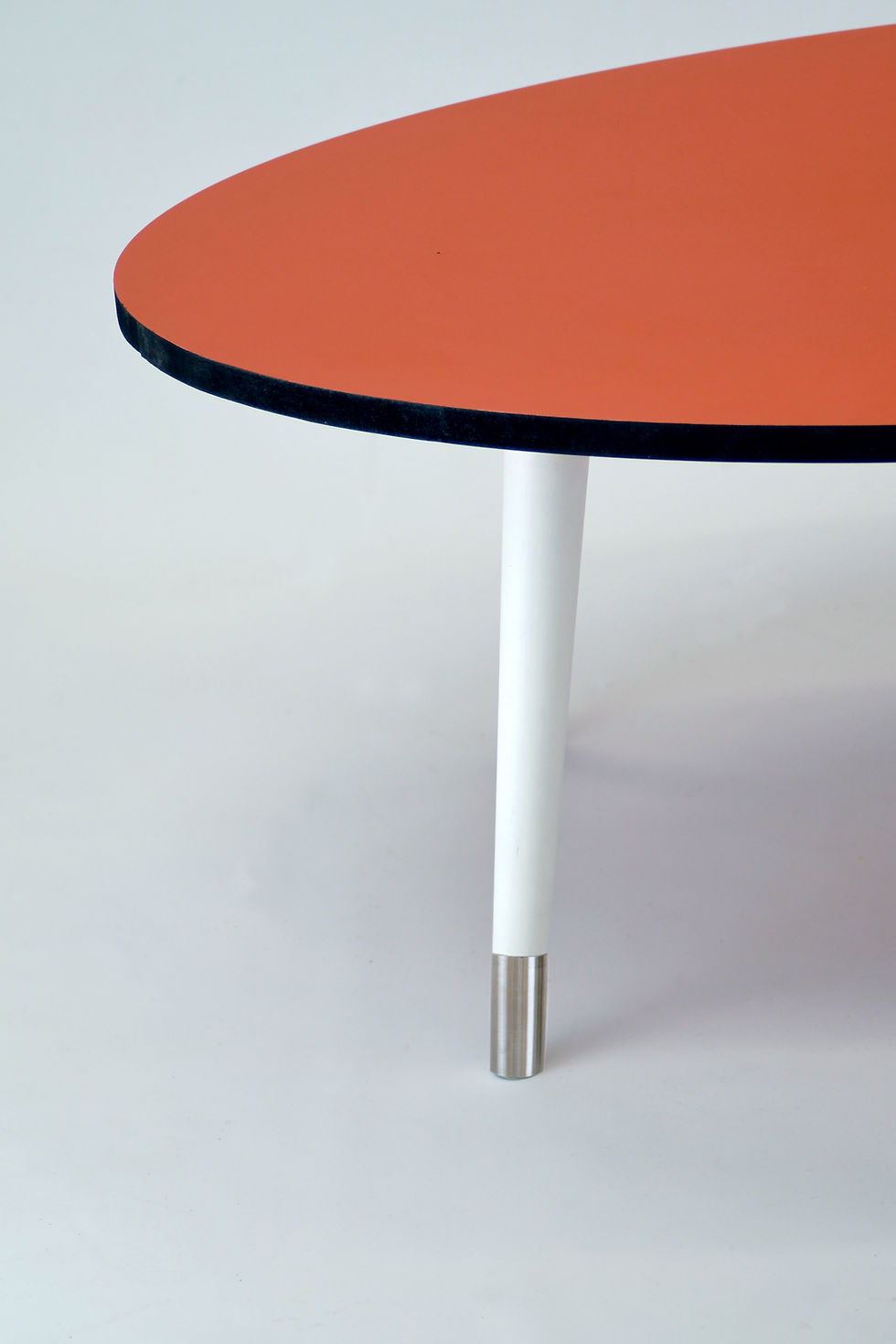 Thumbnail: Oval Orange top coffee table with black edge,tapered legs and stainless steel fe