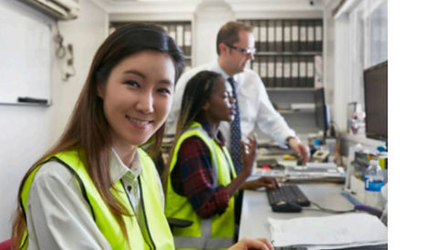 A Trans it Technology worker smiling while working at a data center