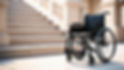 empty wheelchair to the right of a staircase outside.jpg