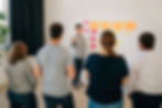Arthur Krier steht vor einem Kanbanboard und hält einen Workshop vor einer Gruppe.