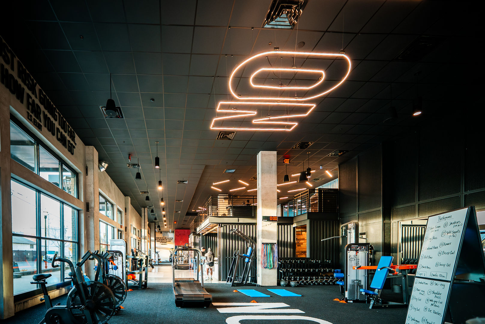 Open fitness training environment with functional workout spaces, custom lighting, and premium athletic amenities.