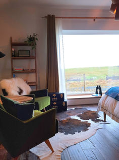 Shows an image of inside our luxury cabin suite. Living area, bed and a beautiful view.
