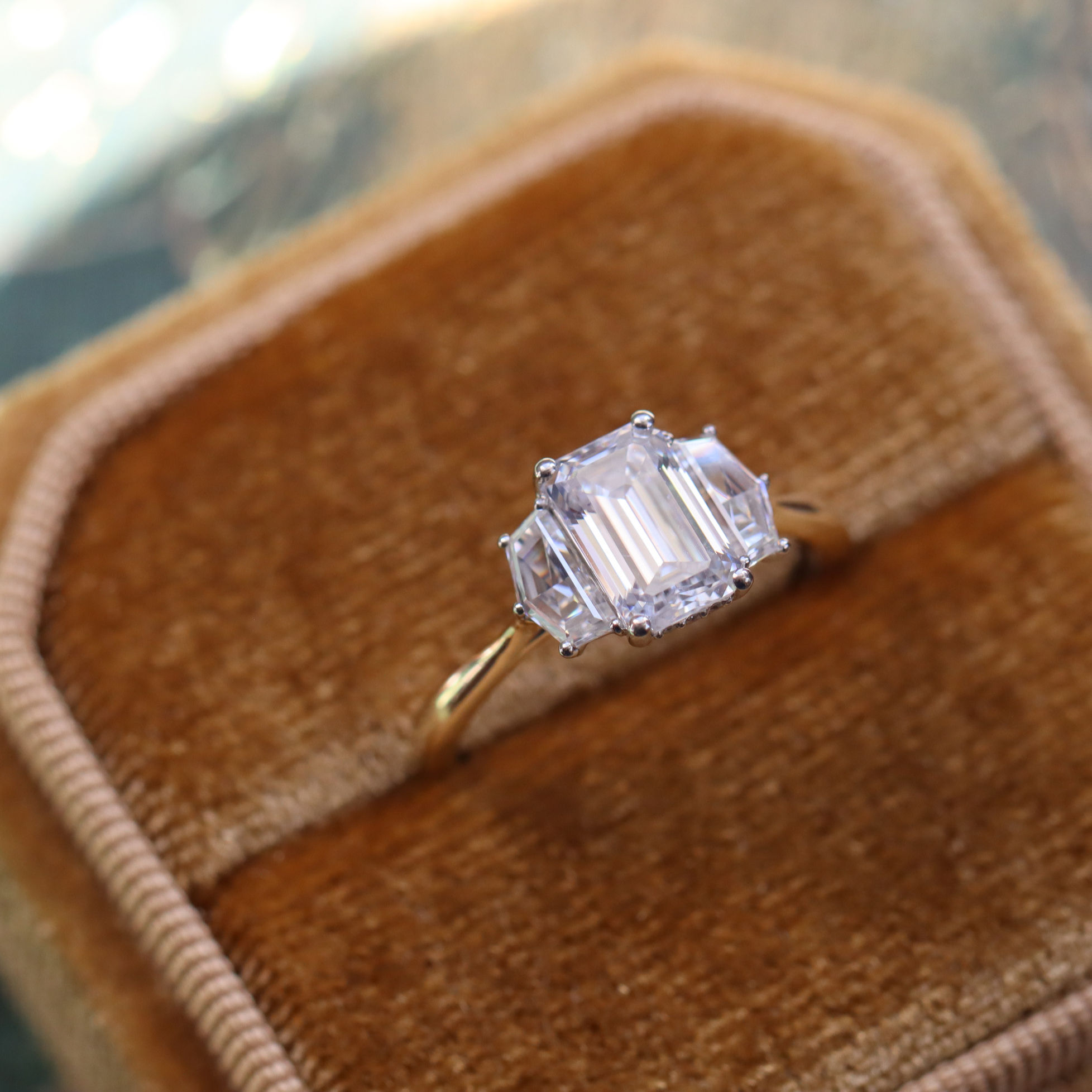 Art deco style engagement ring, set with an emerald cut lab grown diamond center stone and cadillac side stones.