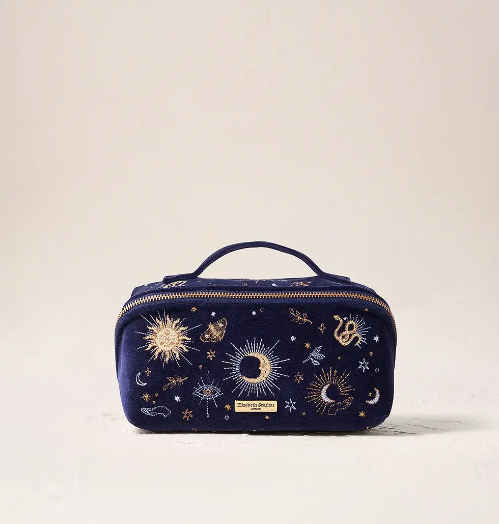 A dark blue travel makeup bag from Elizabeth Scarlett with celestial embroidery on it.