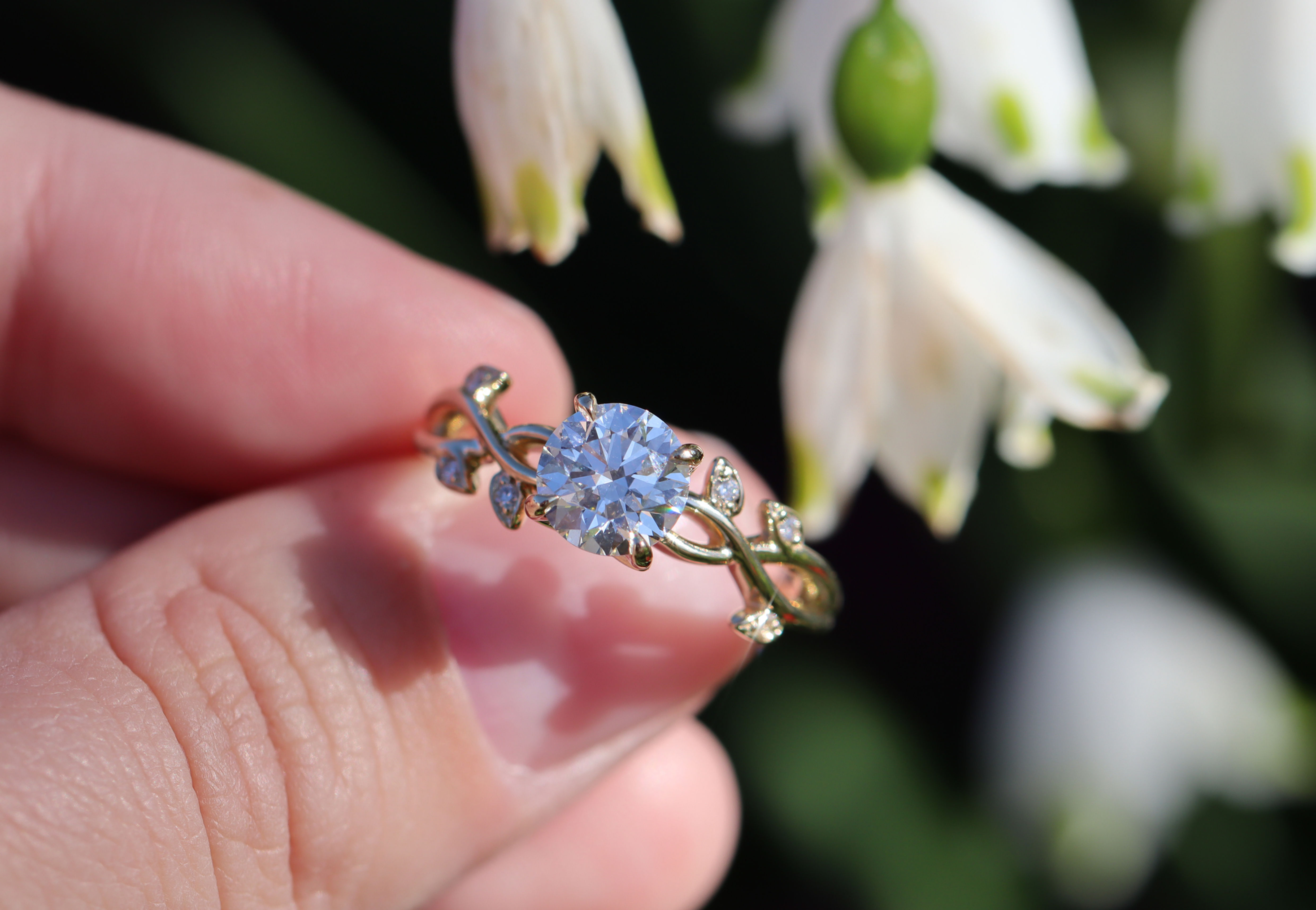 Hand crafted vine leaf engagement ring, set with a round lab grown diamond center.