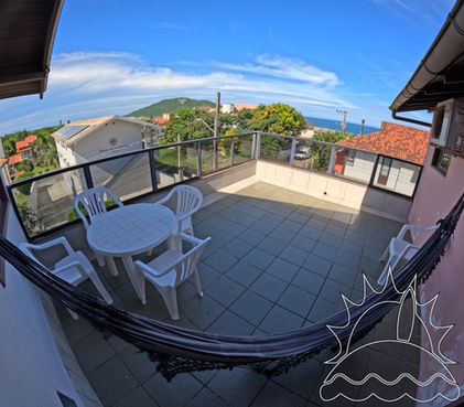 Terraço, vista do mar, céu azul e morro.