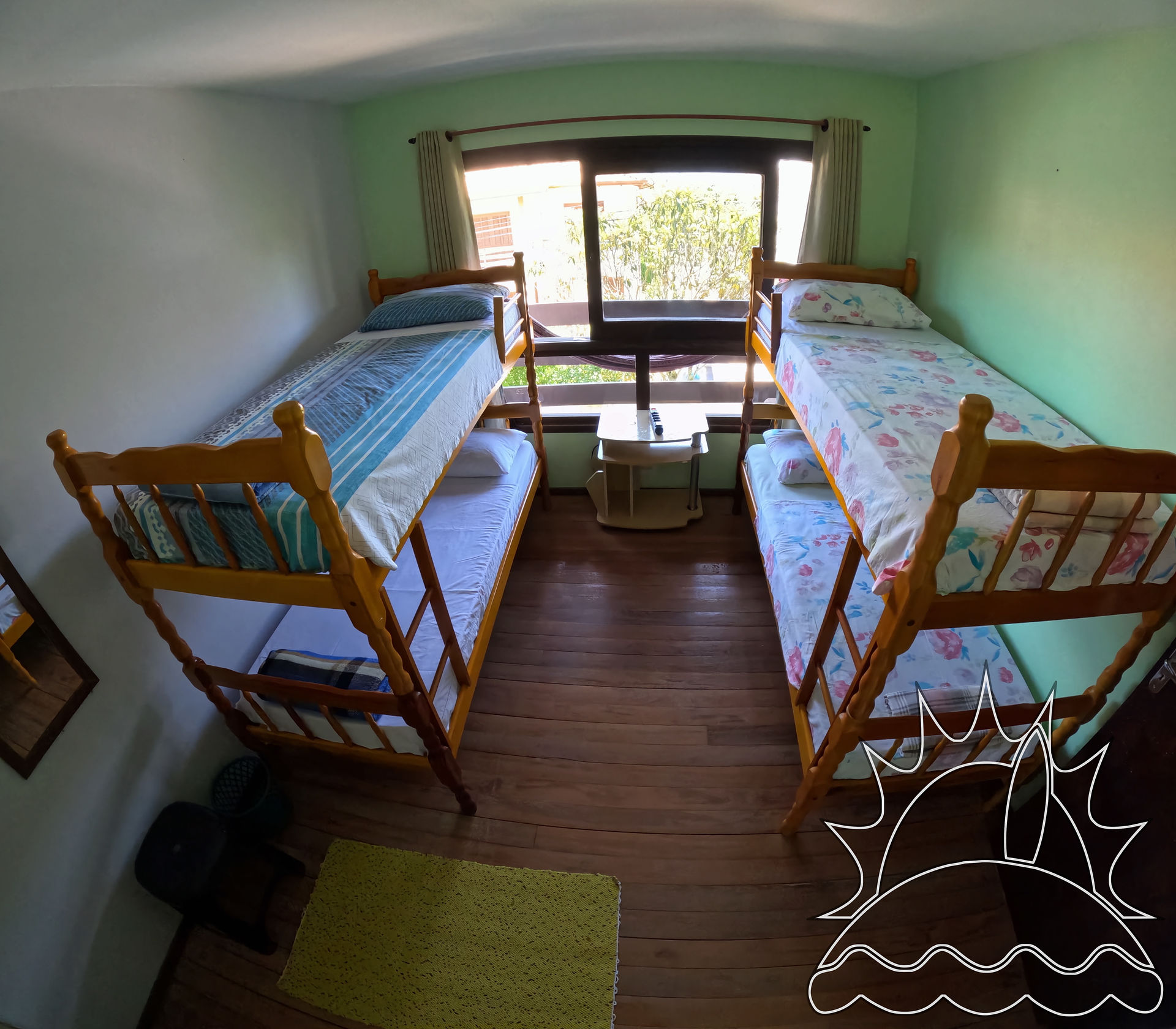 Quarto com janela e dois beliches duplos.