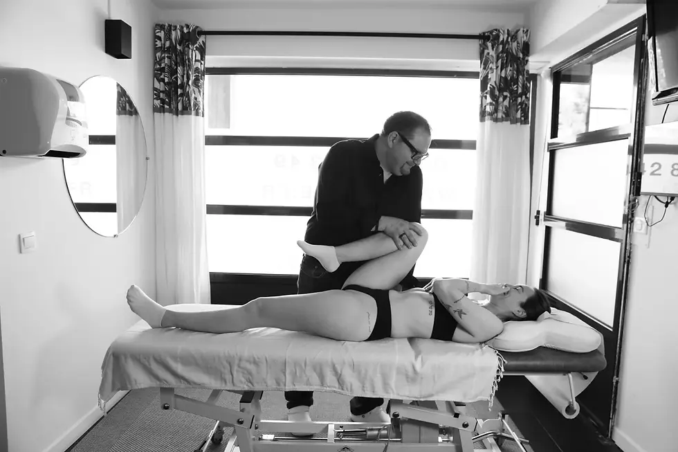 Ostéopathe réalisant une mobilisation de la hanche et du genou d'une patiente allongée sur le dos, cabinet d'Ostéopathie TITONE à Aubagne