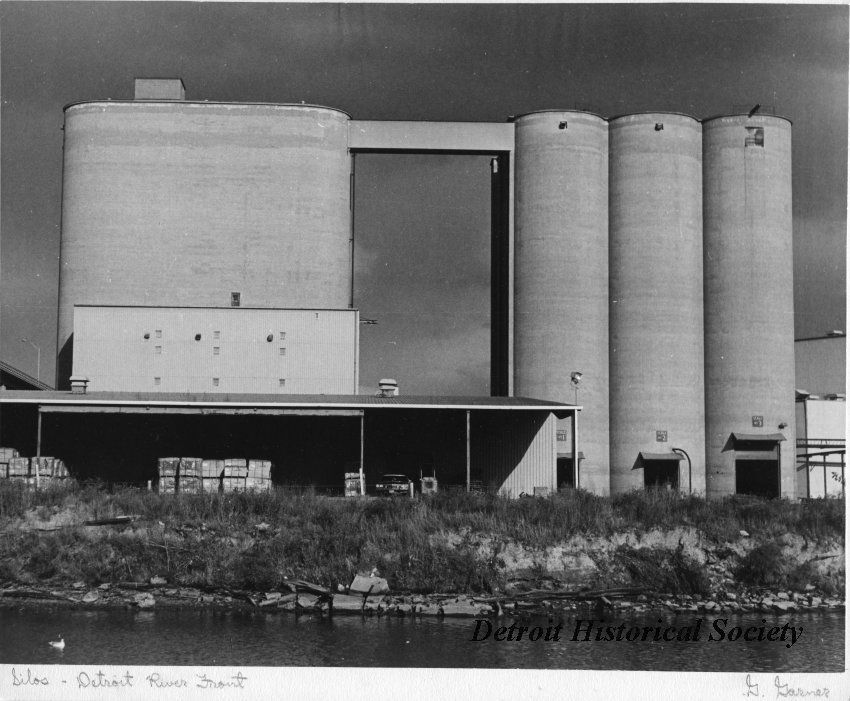 Black and white 1970 photo of four massive interconnected cement silos, one of which bears a strong resemblance to "Silo." Photography by G. Garner, courtesy of Detroit Historical Society.