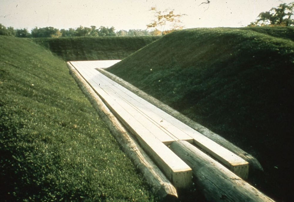 Historic photograph of Stan Dolega's untitled 1974 earthwork and play structure on the north side of Belle Isle, showing the sculpted hilltop and wooden platform co-created with Detroit youth.