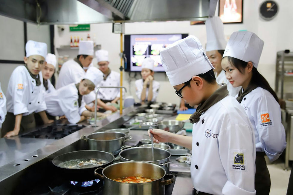 Chefs working at cooking pots in a commercial kitchen