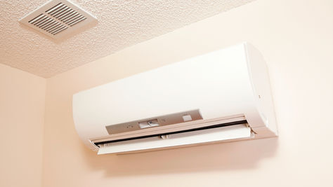 Van Bremen's technician installing a ductless air conditioning system on the exterior wall of a Somerset PA home