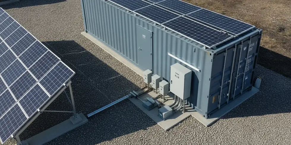 A shipping container set up as a solar power station beside a small ground-mounted solar array