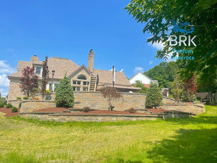 Pittsburgh home exterior featuring multiple concrete finish options including stamped patio and broom finish driveway