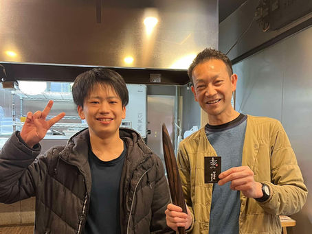 就職の報告に来た塾生と笑顔で写真を撮る黒川塾長