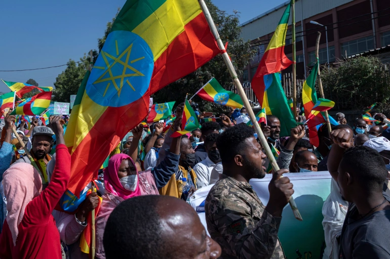 Ethiopians holding their national flags at an event celebrating their military in the capital.