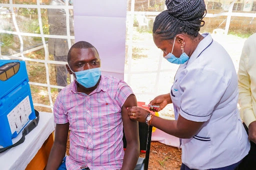 An African man being inoculated by a medical professional.